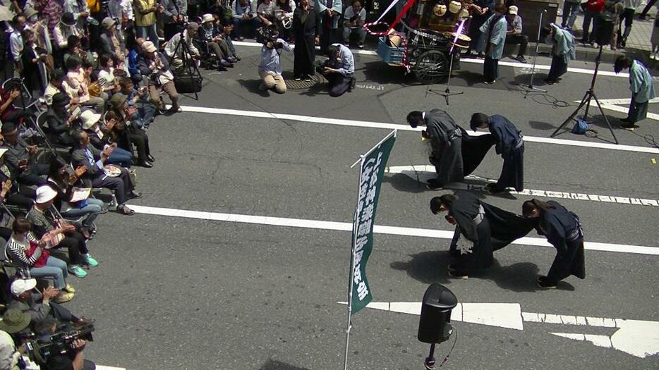 [写真]獅子舞の女性たちに拍手を送る市民ら