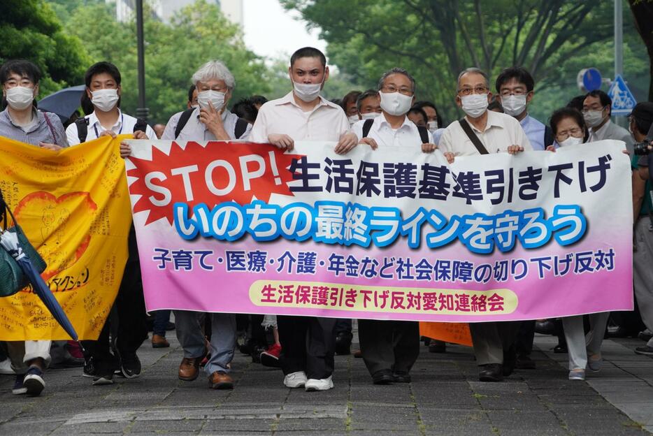 横断幕を手にして、裁判所に向かう原告団（写真：関口威人）