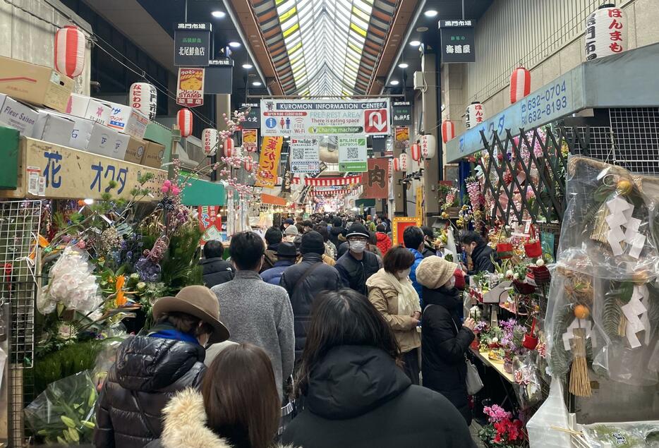 ［写真］食材だけでなく花や正月用のしめ飾りなども並ぶ＝31日正午ごろ、大阪市中央区で、