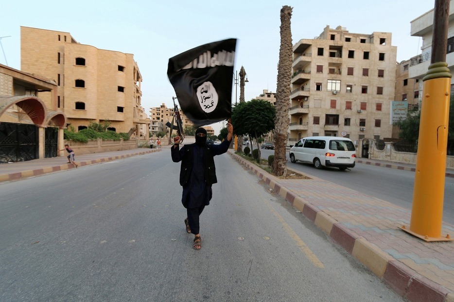 [資料写真]「イスラム国」の旗を振るISのメンバー。2014年6月撮影（ロイター/アフロ）
