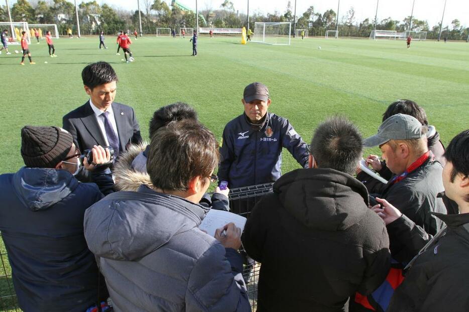 大勢の記者を前に取材現場を仕切る西村さん（写真左）＝名古屋グランパス提供