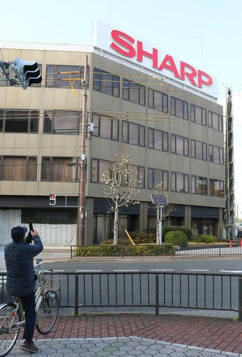 [写真]「SHARP」の看板に高く組み立てられた足場（右）が迫る=1日午後4時半ごろ、大阪市阿倍野区で（撮影：柳曽文隆）