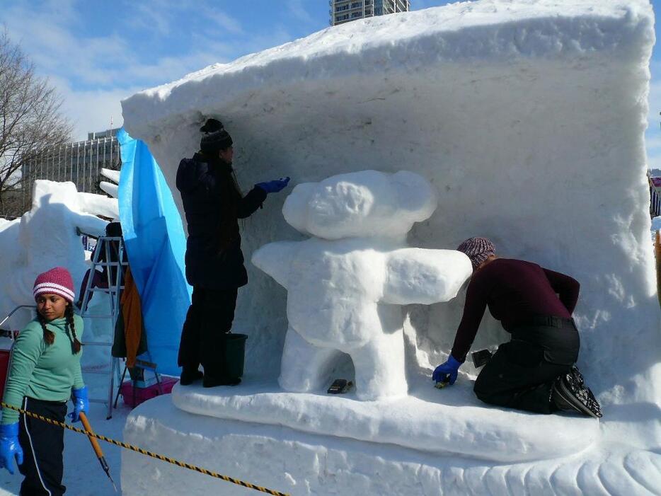 [写真]サーフィンするコアラをモチーフにした小雪像を製作するオーストラリアチーム＝2月6日午後、札幌市