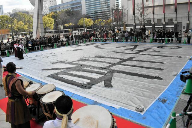 巨大な布に特大の筆で書かれた「坐春風」の文字=2025年1月4日午後1時30分、広島市中区、山中由睦撮影