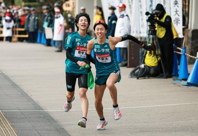 小田原中継所で、1位でたすきをつなぐ青学大6区の野村昭夢（左）と7区の白石光星=吉田耕一郎撮影