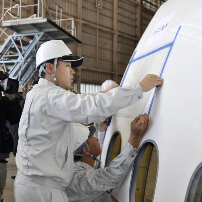 公開された機体表面への塗装の実演＝10日午後、羽田空港