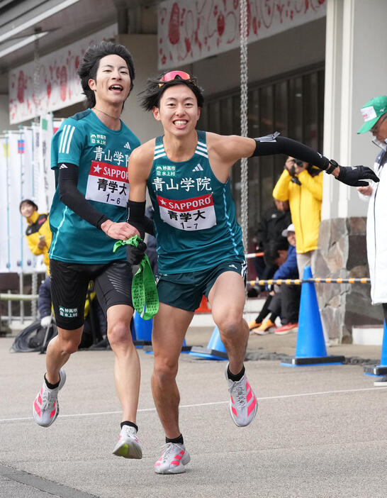 青学大6区野村（左）は7区白石に小田原中継所トップでたすきを渡す（撮影・鈴木みどり）