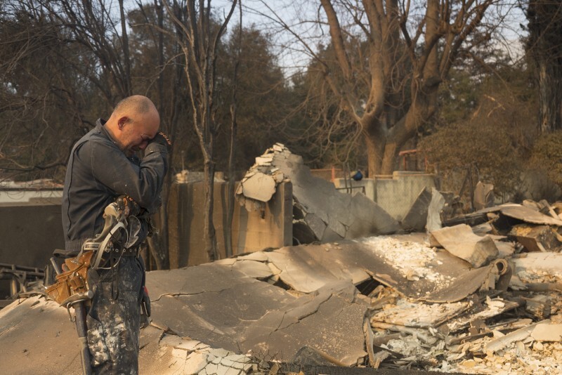 米西部カリフォルニア州で、山火事で被災した自宅前に立つ男性＝2025年1月9日、AP