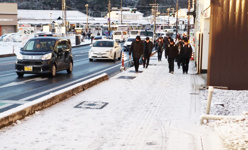 雪で白く染まったJR津山駅付近の歩道を歩く通学生ら＝10日午前7時37分