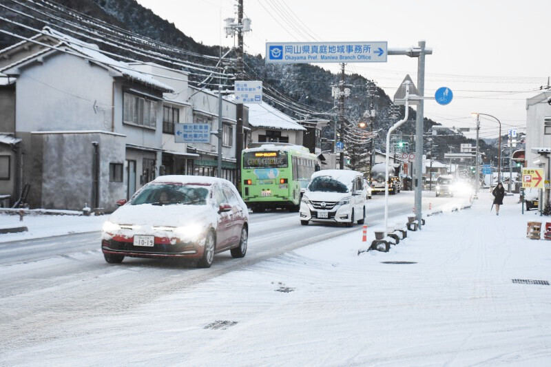 雪が積もり、速度を落として走る車＝10日午前7時3分、真庭市勝山