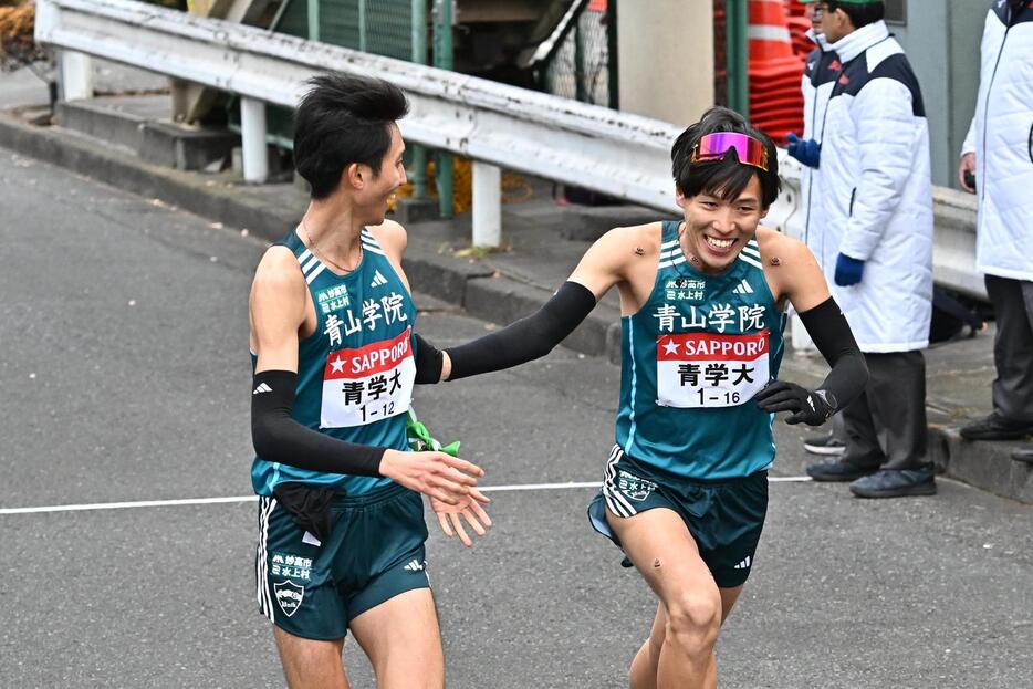 鶴見中継所でトップでタスキリレーする青学大の9区田中（左）と10区小河原（撮影・滝沢徹郎）