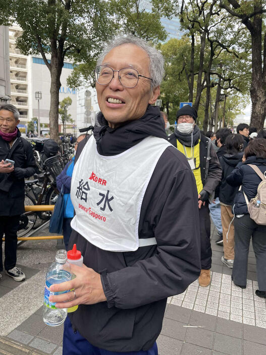 横浜駅前で関東学生連合9区・古川大晃に給水を終えた東大大学院・八田秀雄教授（家族提供）