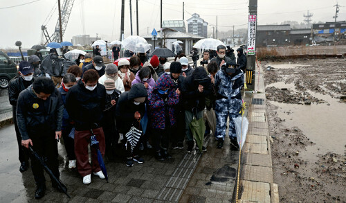 大規模火災が起きた現場近くで犠牲者に祈りをささげる住民ら（１日午後４時１０分、輪島市で）＝冨田大介撮影