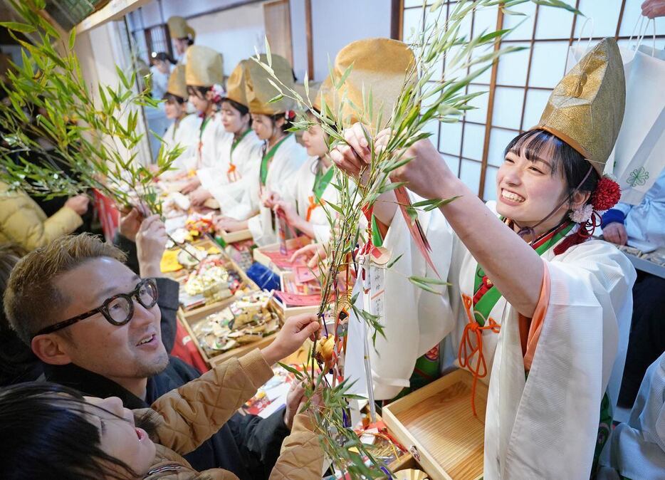 「宵えびす」を迎えた今宮戎神社で、福笹に縁起物を付ける福娘＝9日午後、大阪市浪速区（恵守乾撮影）