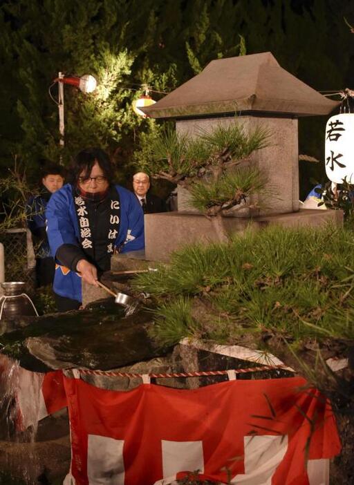 つづら淵の湧き水をすくう年男