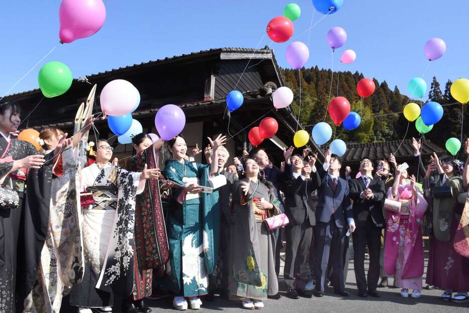 風船を飛ばし節目を祝う参加者＝霧島市のＪＲ大隅横川駅