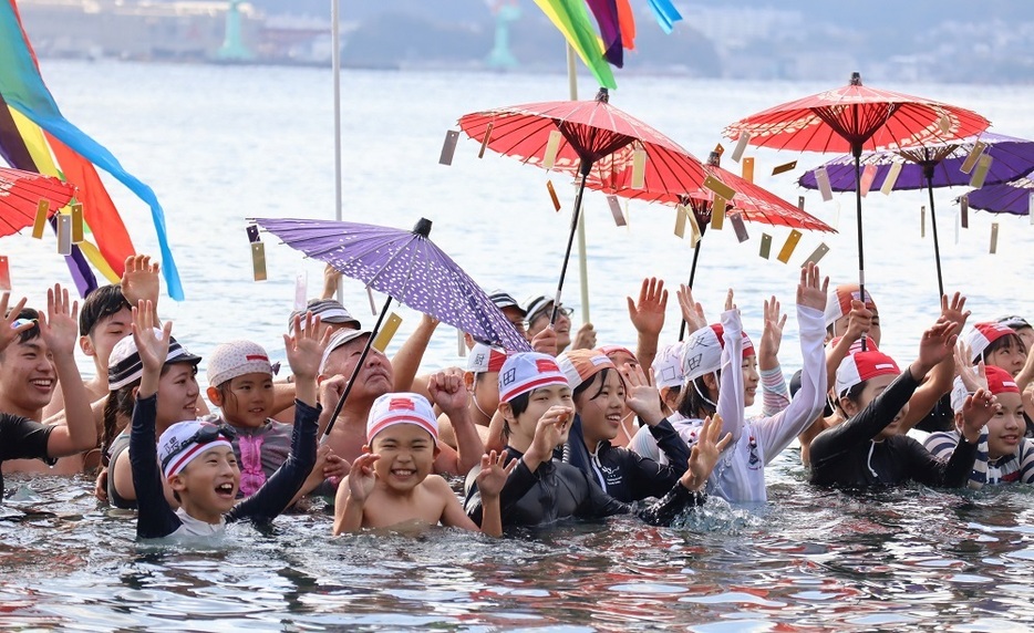 海の中で万歳三唱する児童ら＝長崎市