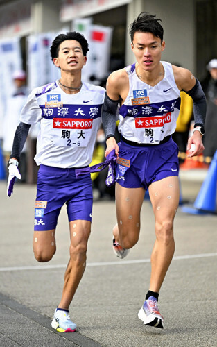 たすきをつなぐ駒大６区の伊藤蒼唯（左）と７区の佐藤圭汰（３日）＝佐々木紀明撮影