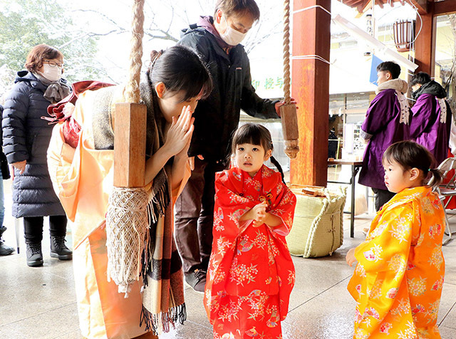 新年の願いを込め、さい銭して手を合わせる参拝客＝山形市・諏訪神社