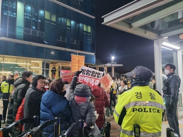 2日夕刻、「尹錫悦即時逮捕を求める緊急行動」集会が行われているソウル龍山区の漢江鎮駅。尹大統領の支持者が警察の規制線の外で「戒厳合法」「弾劾無効」などのスローガンを叫んでいる=コ・ナリン記者