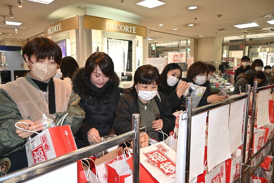 中身を品定めしながら、福袋を買い求める来店客＝1日午前10時40分ごろ、さくら野百貨店八戸店