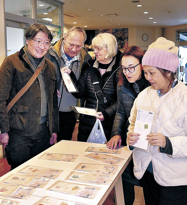 仕上がった和紙を手に笑顔を見せる訪日観光客＝昨年１２月２２日、南砺市の五箇山和紙の里