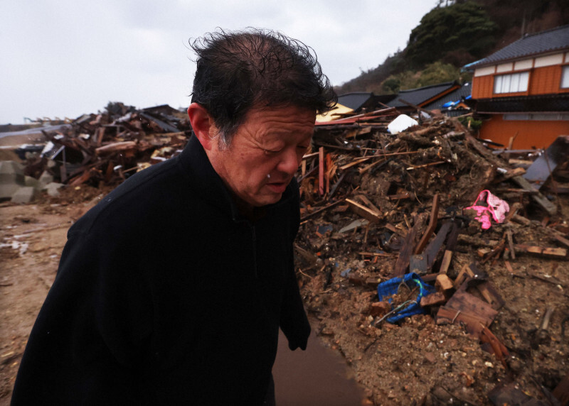 「故郷の空気が吸いたかった」と能登半島地震から1年を前に、珠洲市仁江町の全壊した住居を見に来た川端利活さん（66）。自宅は地震で半壊し、豪雨災害で土砂に飲まれた＝石川県で2024年12月31日、滝川大貴撮影