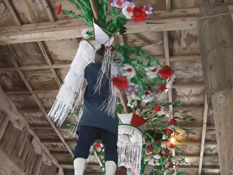 花笠を引き下ろす若者＝６日、郡上市白鳥町、長滝白山神社