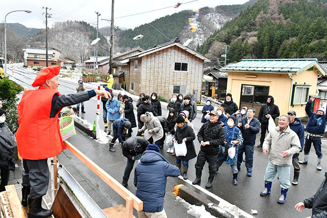 新年の幸せを願った「歳祝いお菓子撒き」＝鶴岡市槙代