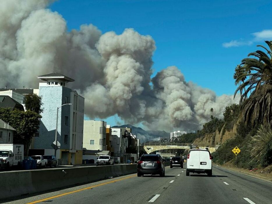 米加州の高級住宅地パシフィック・パリセーズから立ち上る山火事の煙