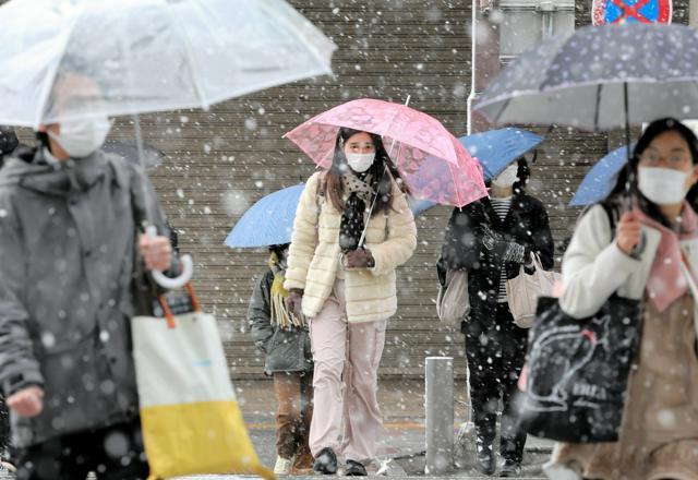 雪が降る中、通勤する人たち=2025年1月10日午前7時55分、名古屋市中村区、溝脇正撮影