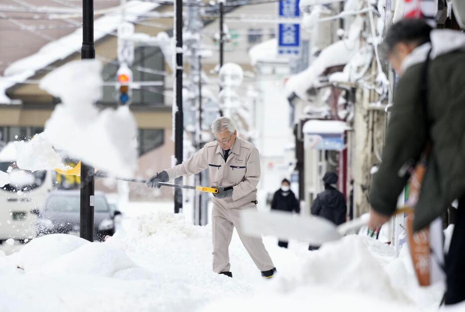 雪が積もった新潟市で除雪する人たち＝10日午前