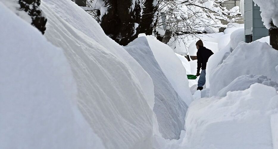 積雪が一時139センチとなった青森市。自宅前や歩道を雪かきする市民＝5日午前、同市桜川2丁目