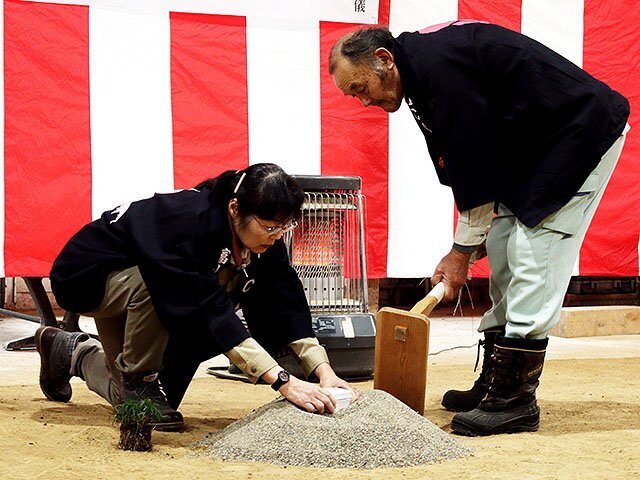 「苅初め鎮物の儀」を行う学生と教員（右）