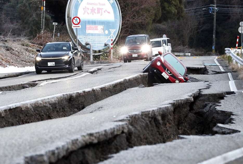 能登半島地震で亀裂が入った道路。燃料補給が阻まれ電波が停止した自治体もあった＝昨年1月2日、石川県穴水町