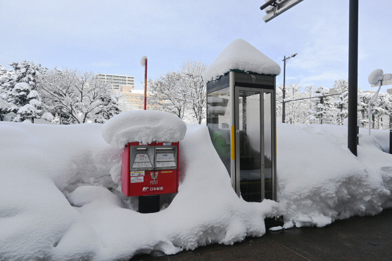 雪をかぶった郵便ポストと電話ボックス＝青森市で2025年1月3日、足立旬子撮影