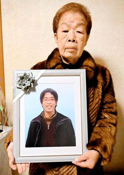 福本さんの遺影を抱く恵子さん