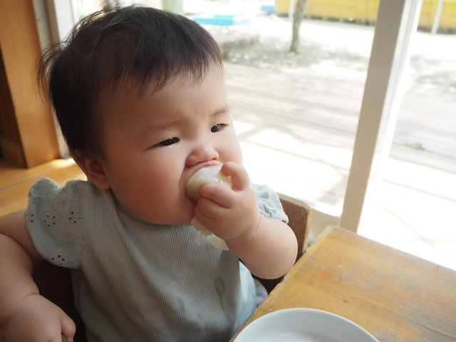 手づかみ食べで意欲を見せるあかちゃん