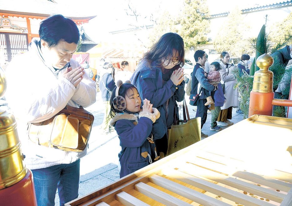 手を合わせて今年の平穏無事や健康を願う参拝者（1日、深志神社）