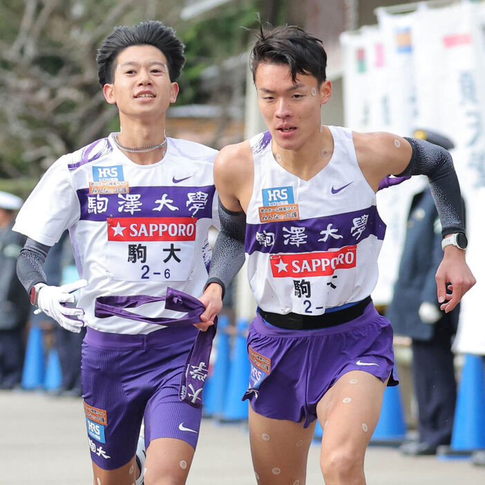 ６区、伊藤蒼唯（左）からタスキを受け取る７区の駒大・佐藤圭汰（カメラ・中島　傑）