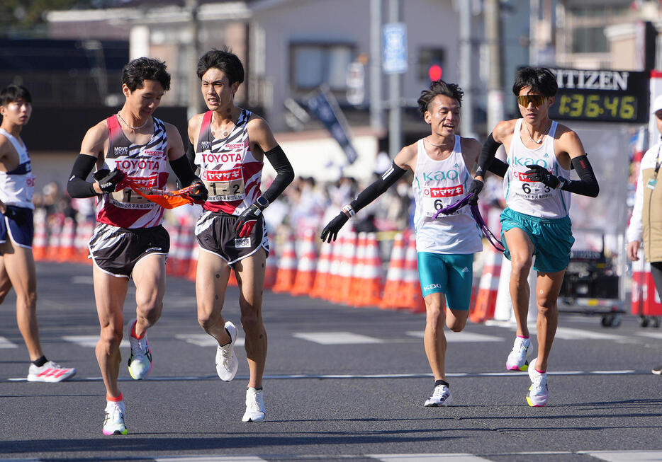 第2中継所、わずかな差でタスキリレーするトヨタ自動車の2区鈴木（中央左）と3区太田（左端）、Kaoの2区池田（中央右）と3区杉山（撮影・足立雅史）