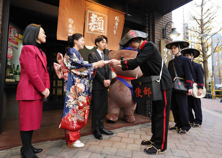 日本郵便は１日午前、年賀状の配達出発式を新宿郵便局（東京都新宿区）で開いた。写真は、創業時などの制服姿で配達する郵便局員ら。