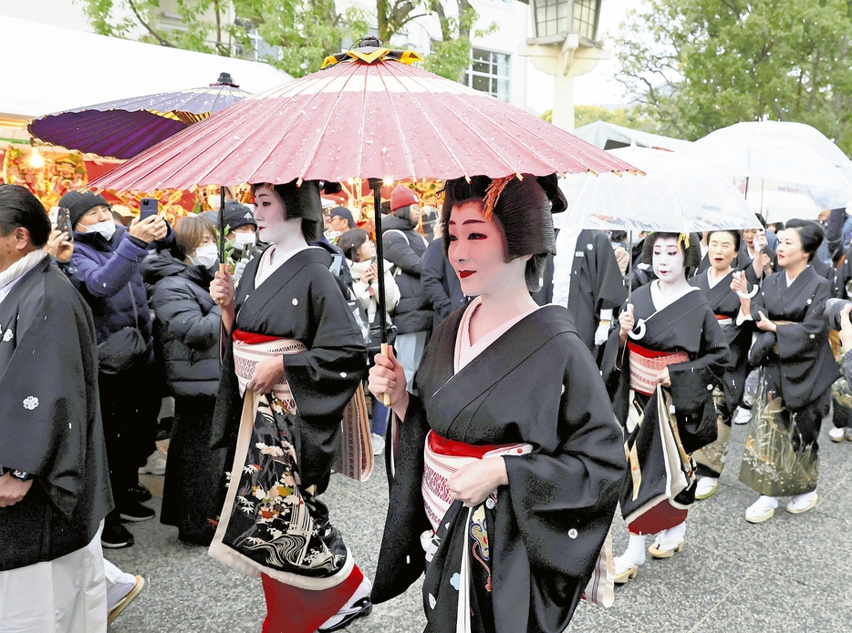 和傘を手に参道を練り歩く博多券番の芸妓ら