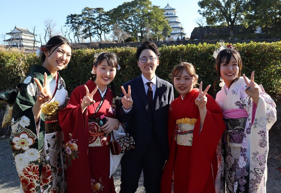 島原城を背景に記念撮影するグループ＝島原文化会館