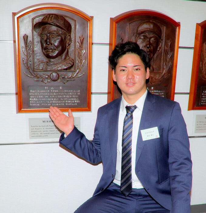 村山実氏のレリーフの前で写真に納まる中日金丸（撮影・河田真司）