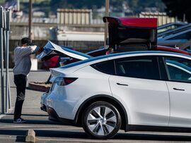 A customer looks at the trunk of a vehicle at a Tesla store in Colma, California. Photographer: David Paul Morris/Bloomberg