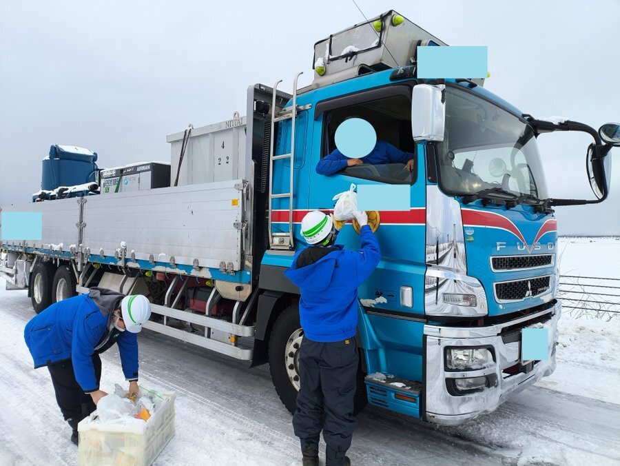 北陸道で運転手に軽食を配布する職員（NEXCO東日本提供）