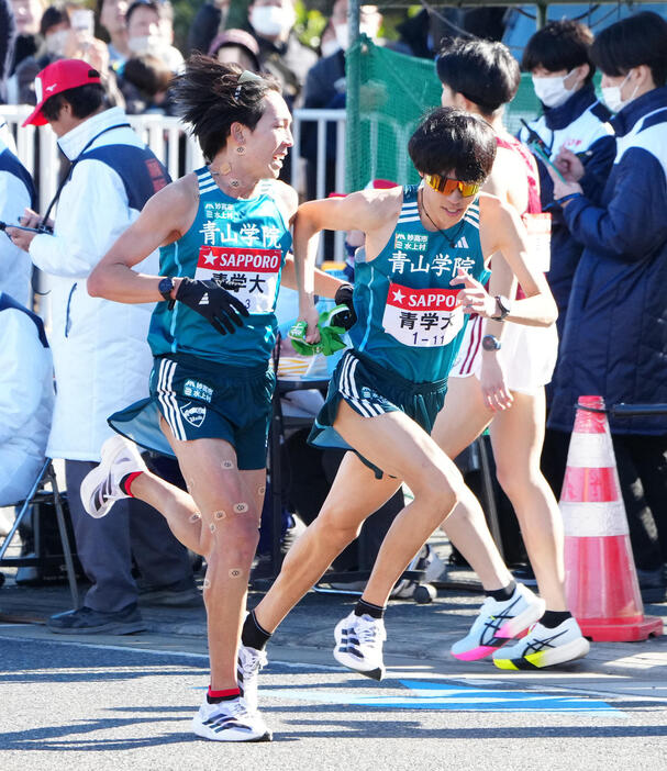 平塚中継所でタスキをつなぐ青学大3区鶴川（左）と4区太田（撮影・江口和貴）