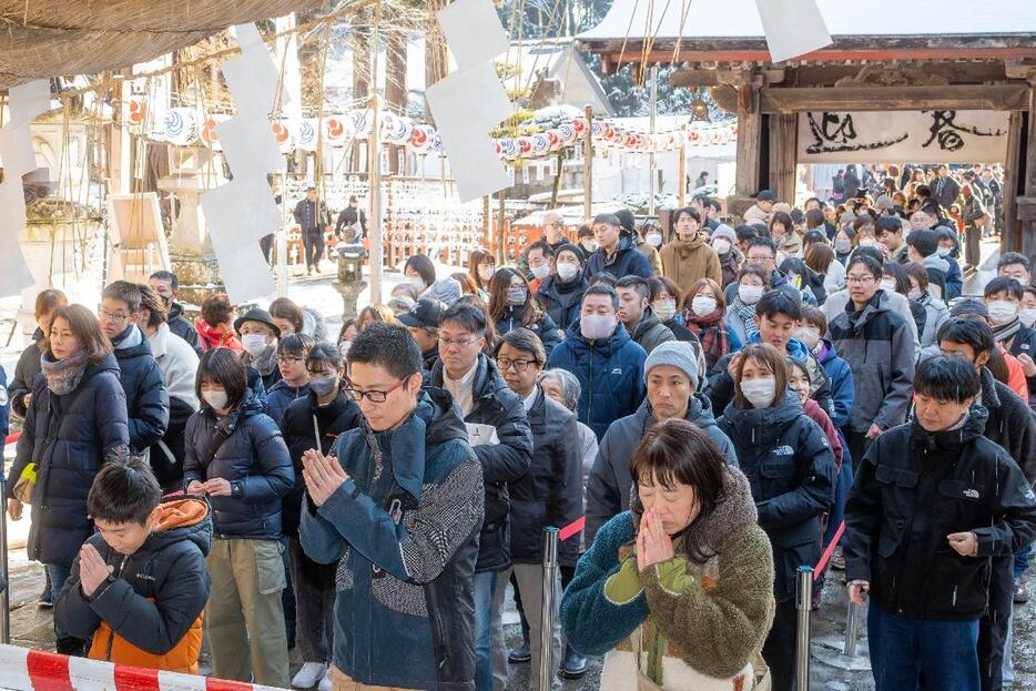 拝殿に向かって手を合わせ、願いを込める参拝者＝午後0時35分ごろ、八戸市の櫛引八幡宮