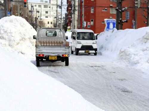 路肩に積まれた雪で道幅が狭くなった車道（６日、青森市で）